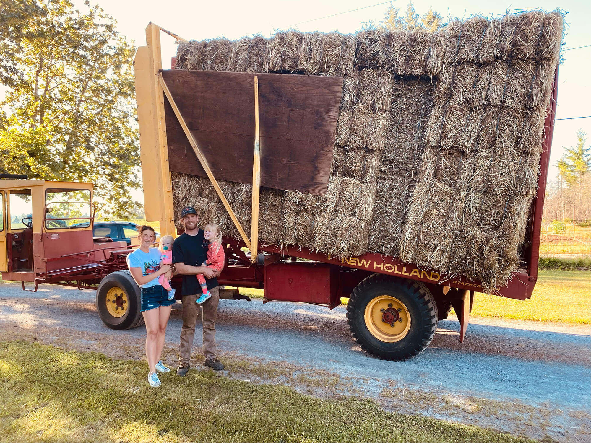 family in front of baled hay