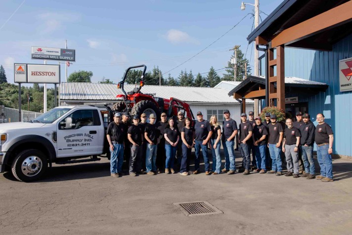 Fischer Mill Supply team members gathered outside the Oregon City facility with service truck and tractor equipment